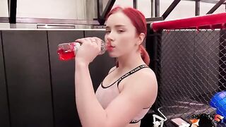 The red-haired girl is having fun with her personal trainer in gym