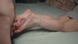 A petite girl shows off her small feet and performs a foot job