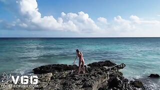A fit girl is playing on the beach naked