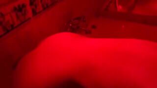 A blonde woman has fun with a large sex toy in the bathroom