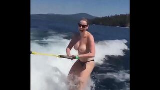 Topless girl water skiing, her tits splash water