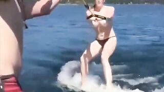 Topless girl water skiing, her tits splash water