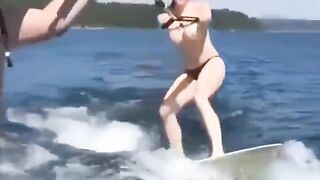 Topless girl water skiing, her tits splash water