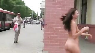 A sexy brunette with a beautiful body poses in public place