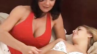 Lesbian beauties fuck with a strap-on in the bedroom