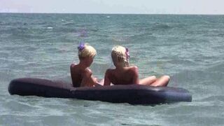 A naked girl is having fun on the beach mattress