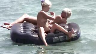 A naked girl is having fun on the beach mattress