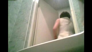 A girl is peeing in the toilet and someone is filming her