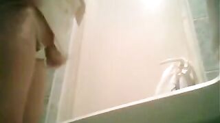 A girl is peeing in the toilet and someone is filming her