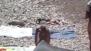 A couple of nudists enjoy each other in a steamy beach scene