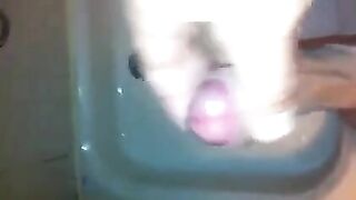 The kid masturbates his dick under a shower stream
