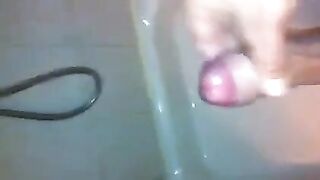 The kid masturbates his dick under a shower stream