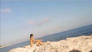 Nude sunbathing of a beautiful girl on the beach