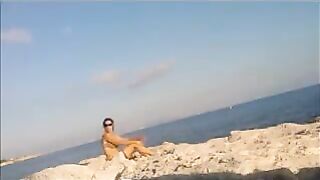 Nude sunbathing of a beautiful girl on the beach
