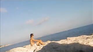 Nude sunbathing of a beautiful girl on the beach