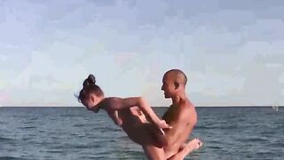 A naked acrobat performs on the beach with amazing agility