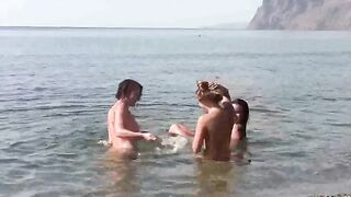 A group of nudists enjoy fun and sex on the beach
