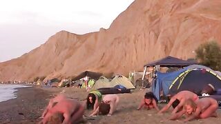 A group of naked people playing volleyball on the beach is really cool